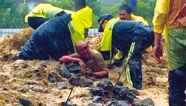 Lực lượng cứu hộ đang nỗ lực cứu người đàn ông bị vùi trong bùn đất