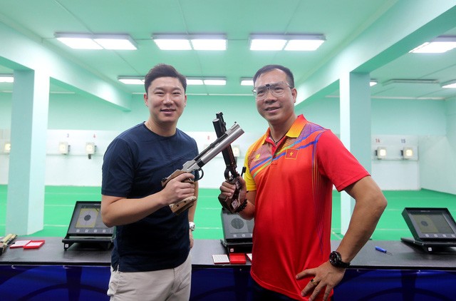 Hai nhà vô địch Olympic môn bắn súng, xạ thủ Hoàng Xuân Vinh (phải) của Việt Nam và Jin Jong-Oh (Hàn Quốc) chụp ảnh chung với nhau tại Hà Nội.