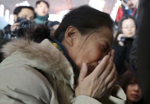 Người thân của một hành khách trên chuyến bay MH370 ôm mặt khóc trong lúc chờ đợi thông tin ở sân bay quốc tế Bắc Kinh. Ảnh: Reuters.
