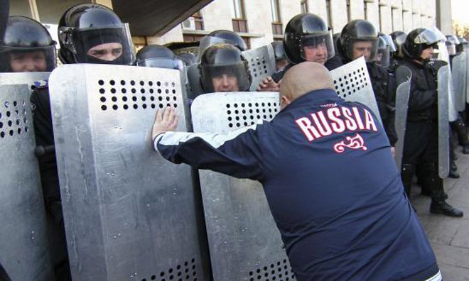 Một người biểu tình ủng hộ Nga đối đầu với cảnh sát bên ngoài tòa nhà chính quyền thành phố Donetsk. 