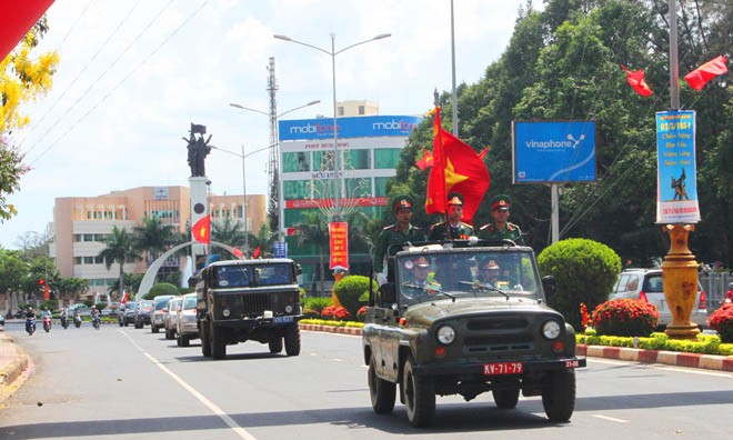 Đoàn xe chở hài cốt liệt sĩ đi qua tượng đài chiến thắng Buôn Ma Thuột. 
