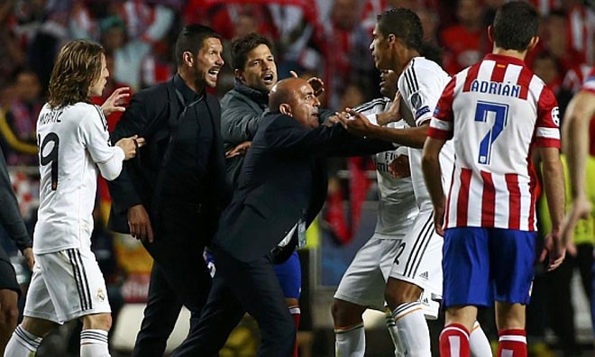 HLV của Atletico Madrid, Diego Simeone chạy vào sân và sửng cồ với hậu vệ Raphael Varane của Real Madrid.
