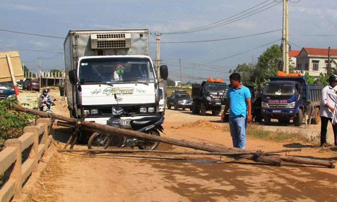 Dân dùng cây gỗ, xe máy chắn ngay trước đầu xe tải phản đối gây ô nhiễm. Ảnh: Ngọc Văn.
