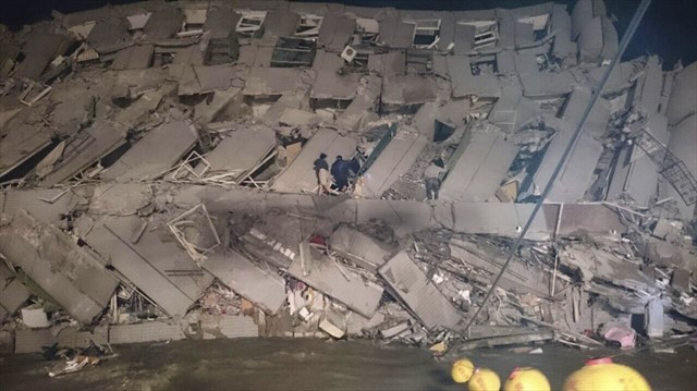 Đội cứu hộ tiếp cận căn chung cư bị sập trong động đất.