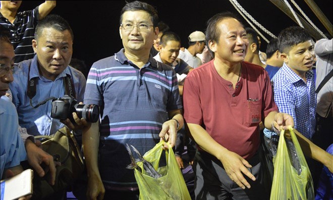 Bộ trưởng Trương Minh Tuấn và Phó chủ tịch tỉnh Quảng Bình Trần Tiến Dũng chọn mua cá ngừ. Ảnh: Zing 