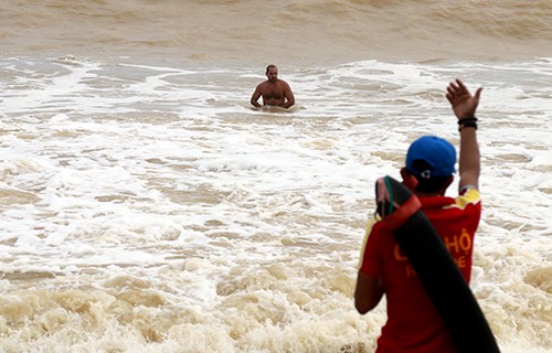 Lực lượng cứu hộ ra hiệu, yêu cầu du khách người nước ngoài tắm ở biển Nha Trang vào bờ, ngày 28/12. Ảnh: Xuân Ngọc 