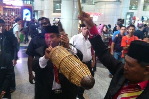 Pháp sư Ibrahim Mat Zin hôm qua thực hiện nghi thức tâm linh tại lối vào của Sân bay Quốc tế Kuala Lumpur. Ảnh: Star