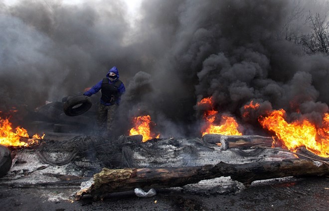Người biểu tình đốt lốp xe chuẩn bị đối phó với lực lượng cảnh sát đặc nhiệm. (Nguồn: AFP/TTXVN)