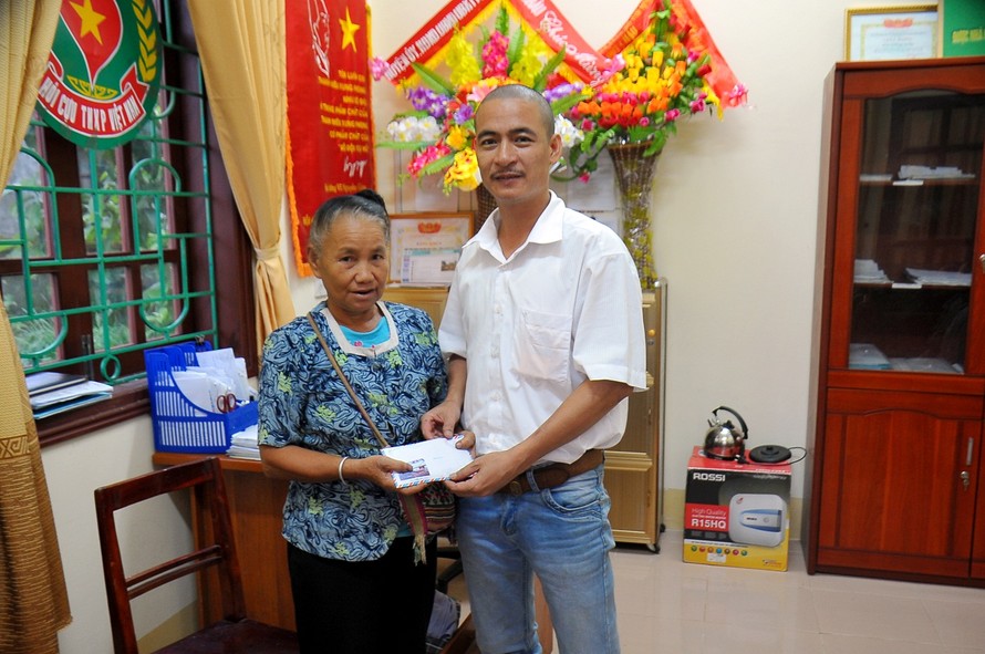 Đại diện báo Tiền phong trao 45 triệu đồng của doanh nghiệp hỗ trợ bà Hà Thị Lan, cựu TNXP Nghệ An. 