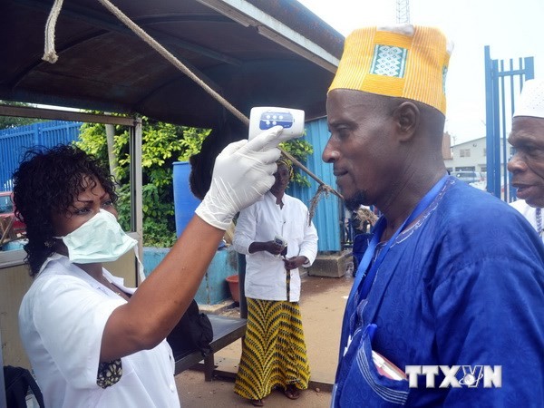 Nhân viên y tế kiểm tra thân nhiệt của hành khách tại một bến tàu ở Conakry, Guinea, nhằm ngăn chặn sự lây lan của virus Ebola. (Nguồn: AFP/TTXVN)