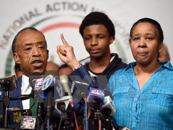 Chủ tịch Hội hành động quốc gia Al Sharpton (trái), Esaw Garner (phải) - vợ của người da màu thiệt mạng Eric Garner cùng con trai Emory Garner (giữa) trong buổi họp báo tại thủ đô Washington, DC, Mỹ ngày 3/12. (Nguồn: AFP/TTXVN)