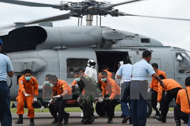 Cảnh sát Indonesia và nhân viên cứu hộ chuyển thi thể nạn nhân máy bay QZ8501 từ Biển Java về Pangkalan Bun ngày 2/1/2015. (Nguồn: AFP/TTXVN)