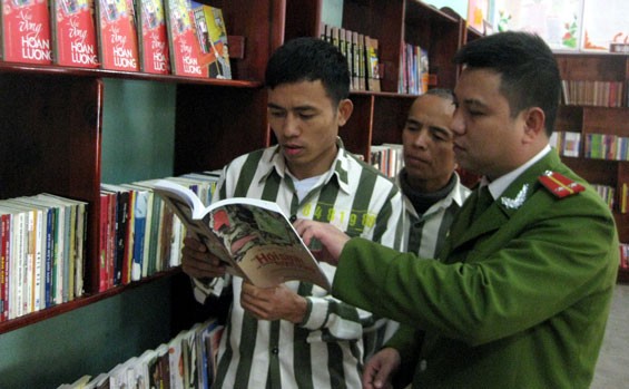 Trung úy Nguyễn Anh Tùng, cán bộ phụ trách quản lý thư viện, Tổ giáo dục phân trại 1, hướng dẫn cho các trại viên lựa chọn sách đọc theo sở thích.