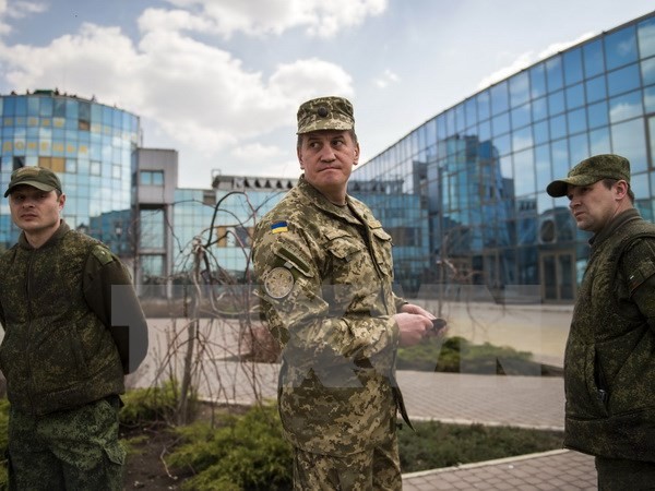 Sỹ quan quân đội Ukraine Andre Leshinski (giữa) phối hợp điều tra cùng sỹ quan Nga và nhân viên OECD tại Jabunki, gần sân bay Donetsk ngày 13/4. (Nguồn: AFP/TTXVN)