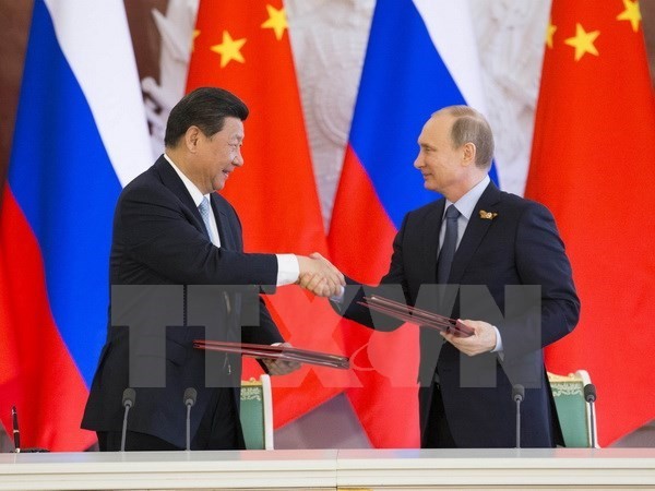 Chủ tịch Tập Cận Bình (trái) và Tổng thống Vladimir Putin trao đổi văn kiện sau lễ ký các thỏa thuận hợp tác song phương. Nguồn: THX/TTXVN