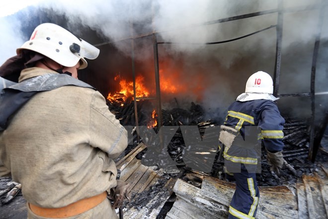 Lính cứu hỏa dập lửa đám cháy khu chợ ở Donetsk sau vụ pháo kích trong xung đột. Nguồn: AFP/TTXVN