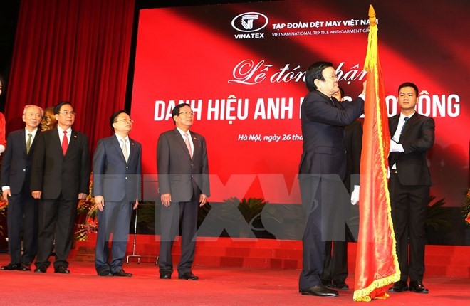 Chủ tịch nước Trương Tấn Sang gắn danh hiệu Anh hùng Lao động lên lá cờ truyền thống của Tập đoàn Dệt may Việt Nam. Ảnh: Nguyễn Khang/TTXVN