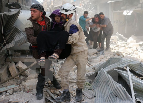 Lực lượng phòng vệ dân sự Syria sơ tán người bị thương khỏi hiện trường một vụ không kích tại Hayy Aqyul, thành phố Aleppo ngày 22/4. (Nguồn: AFP/TTXVN)