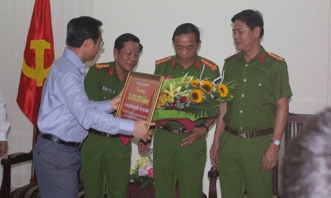 Ông Nguyễn Xuân Anh tặng hoa cùng tiền thưởng 30 triệu đồng cho Công an Thành phố vì có thành tích phá án. 