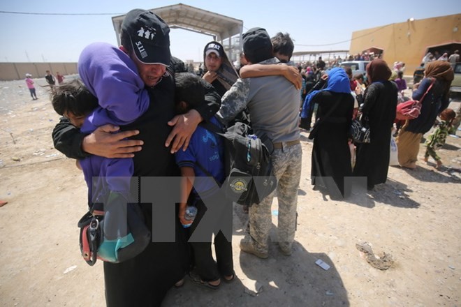 Một nhân viên an ninh Iraq vui mừng gặp lại người thân sau nhiều tháng xa cách tại trại tị nạn dành cho những người dân Iraq chạy khỏi các khu vực bị IS chiếm đóng ở phía nam Mosul. (Nguồn: AFP/TTXVN)