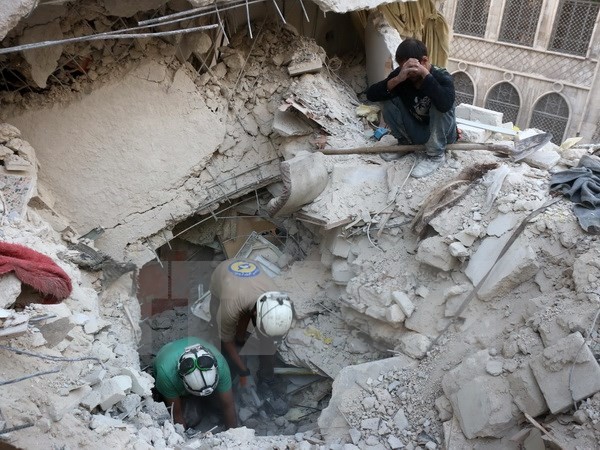 Tình nguyện viên Syria tìm kiếm người bị mắc kẹt trong những đống đổ nát sau một vụ không kích tại Aleppo ngày 4/10. (Nguồn: AFP/TTXVN)