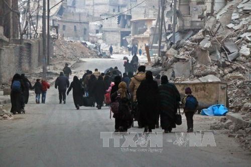 Người dân Syria rời khỏi khu vực Sukkari để đến khu vực an toàn hơn do quân nổi dậy chiếm giữ ở đông nam thành phố Aleppo ngày 12/12. Ảnh: AFP/TTXVN.