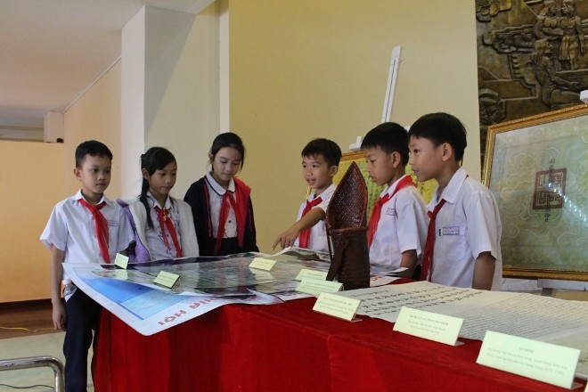 Các em học sinh chăm chú tham quan các cổ vật triển lãm