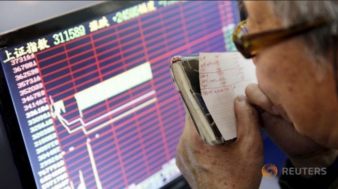 Nhà đầu tư theo dõi chỉ số chứng khoán sau khi thị trường chứng khoán Trung Quốc bị 'sập sàn' ngày 7/1. Ảnh: Reuters