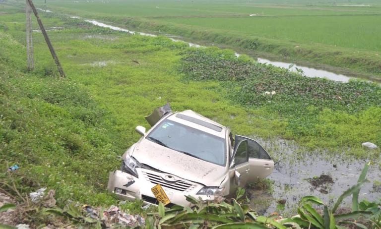 Chiếc xe mang biển Lào bị tàu đâm, hất văng xuống ruộng cạnh đường sắt.