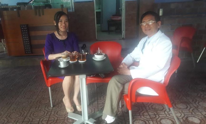 "Đại gia" Lê Ân cùng vợ ngồi quán cà phê "vỉa hè" chờ tới giờ dự tòa. Ảnh: Tân Châu