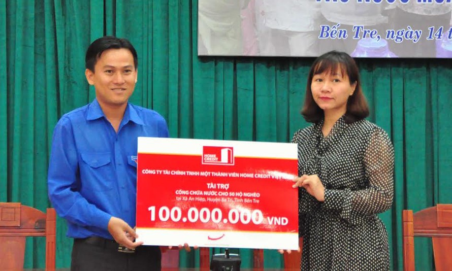 Bà Vương Thủy Tiên, Thành viên Hội đồng thành viên Cty Tài chính Home Credit Việt Nam (bên phải) trao bảng tượng trưng 100 triệu đồng cho đại diện Tỉnh Đoàn Bến Tre.