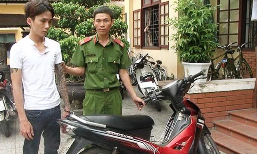 Lương Văn Lợi (bìa trái) bên cạnh tang vật là chiếc xe gắn máy do đối thanh niên này lấy trộm. 
