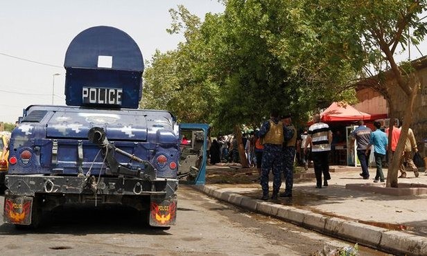 Cảnh sát canh gác tại vị trí xảy ra đánh bom tự sát ở khu Kadhimiya, phía bắc Baghdad ngày 24/7.