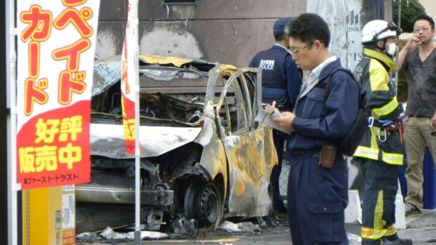 Cảnh sát Nhật Bản đang làm việc ở khu vực chiếc xe bị bốc cháy sau vụ nổ liên hoàn. Ảnh: AFP