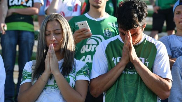 Người hâm mộ chắp tay cầu nguyện cho các nạn nhân rơi máy bay xấu số. Ảnh: AFP