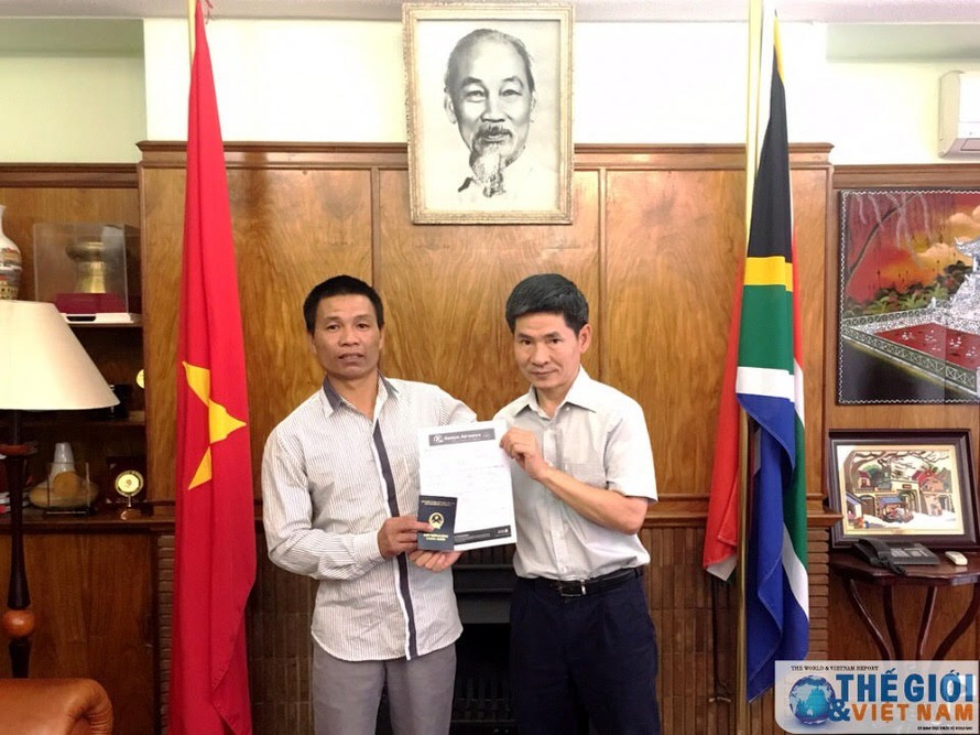 Đại diện Đại sứ quán trao vé máy bay và giấy thông hành cho anh Nguyễn Văn Thanh. (nguồn: Đại sứ quán Việt Nam tại Nam Phi) 