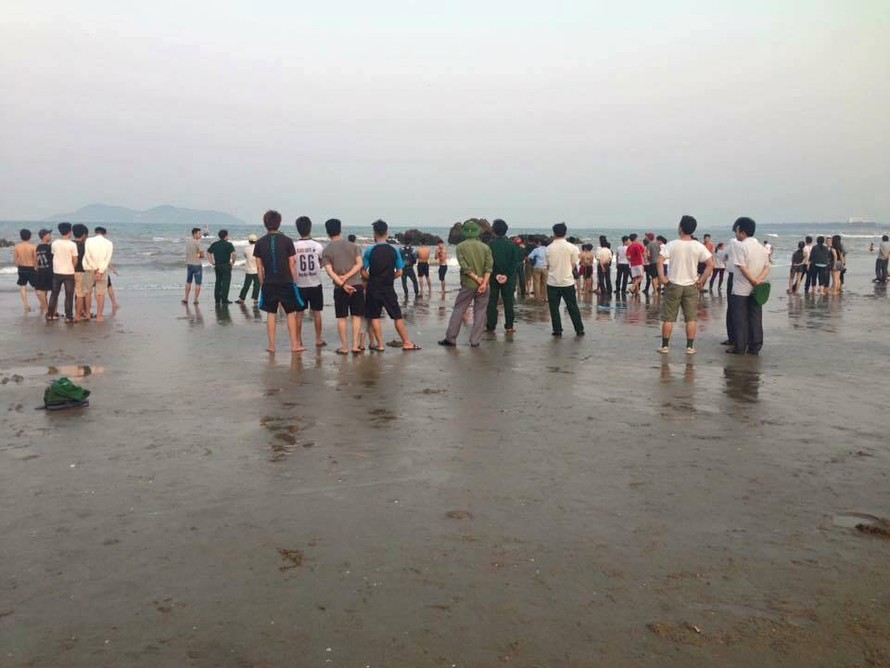 Người dân tập trung nơi bãi biển xảy ra vụ hai học sinh bị sóng cuốn mất tích khi đi chụp ảnh kỷ yếu.