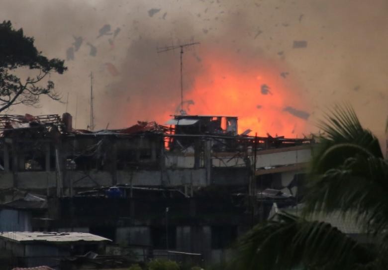 Lửa bốc lên sau khi máy bay ném bom OV-10 không kích xuống thành phố Marawi. Ảnh: Reuters