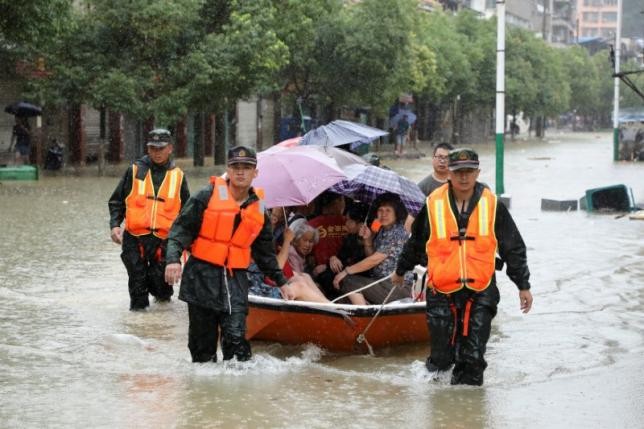 Đội cứu hộ hỗ trợ đưa người dân vùng lũ đến nơi an toàn. Ảnh: Reuters