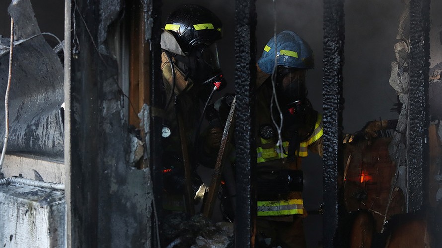 Nhân viên cứu hoả làm việc tại hiện trường vụ cháy bệnh viện. Ảnh: Reuters