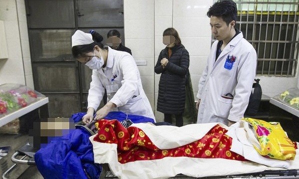 Ông Huang vẫn còn sống thời điểm được đưa đến nhà tang lễ. Ảnh: SCMP