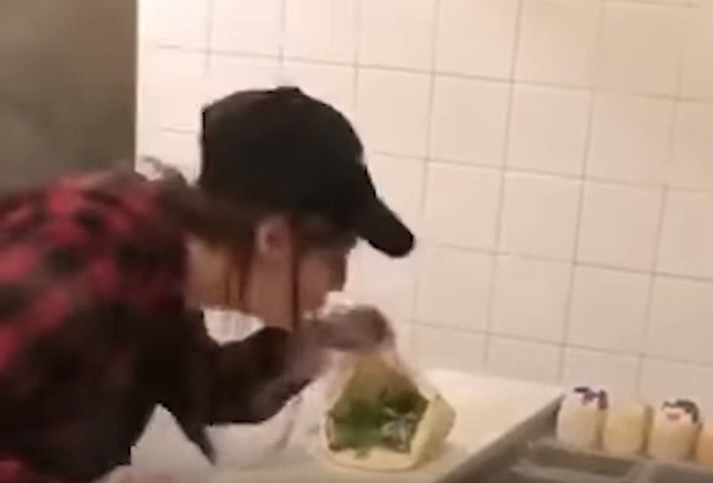 Nữ nhân viên nhổ nước bọt vào bánh sandwich cho khách. Ảnh cắt từ video