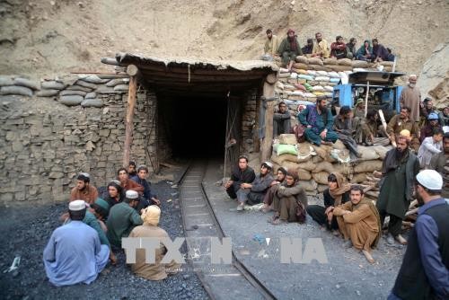 Công nhân chờ bên ngoài khu vực sập mỏ than ở Marwar ngày 5/5. Ảnh: THX/TTXVN