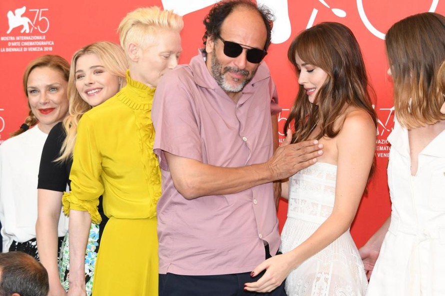 Đạo diễn Luca Guadgnino đặt tay lên ngực Dakota Johnson trong khi nữ diễn viên tỏ ra bối rối.
