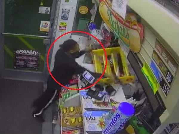 "Nữ quái" giơ súng uy hiếp nhân viên cửa hàng tiện lợi. Ảnh cắt từ video