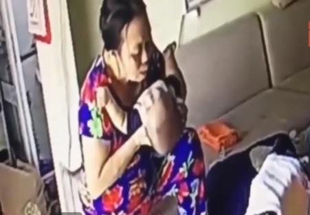 Nữ giúp việc nhổ nước bọt vào miệng đứa bé chưa đến 6 tháng tuổi. Ảnh cắt từ clip