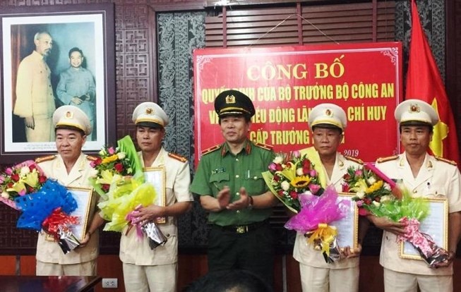 Thiếu tướng Vũ Xuân Viên (giữa) trao quyết định cho các trưởng phòng. Ảnh: HẢI HIẾU