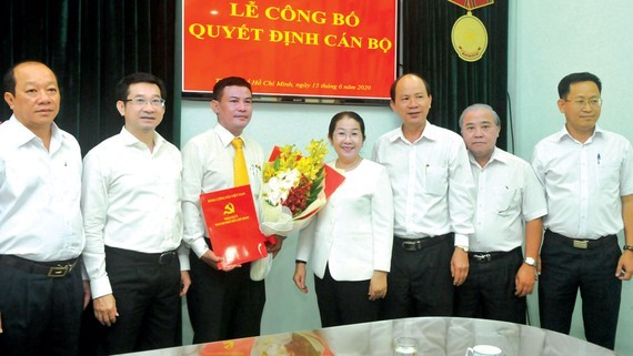 Phó Bí thư Thành ủy TPHCM Võ Thị Dung trao quyết định và tặng hoa chúc mừng đồng chí Lê Kim Hiếu. Ảnh: SGGP