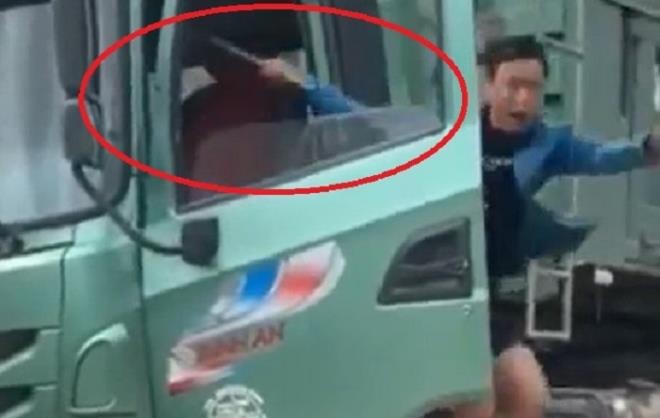 Tài xế xe tải cầm theo tuýp sắt đe dọa thanh tra giao thông. (Ảnh cắt từ clip)