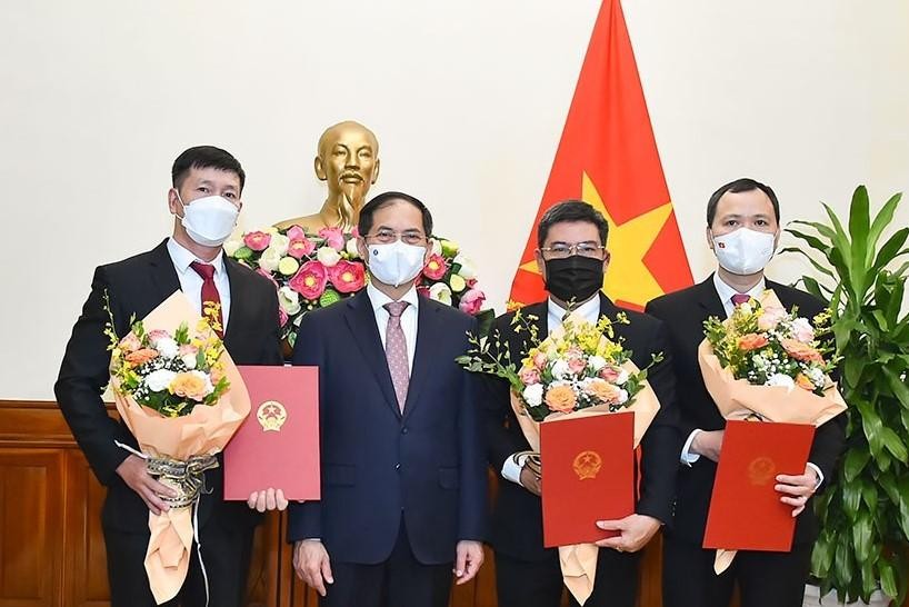 Bộ trưởng Bộ Ngoại giao Bùi Thanh Sơn trao quyết định và chúc mừng các cán bộ được bổ nhiệm giữ chức vụ mới. Ảnh: Báo Chính phủ